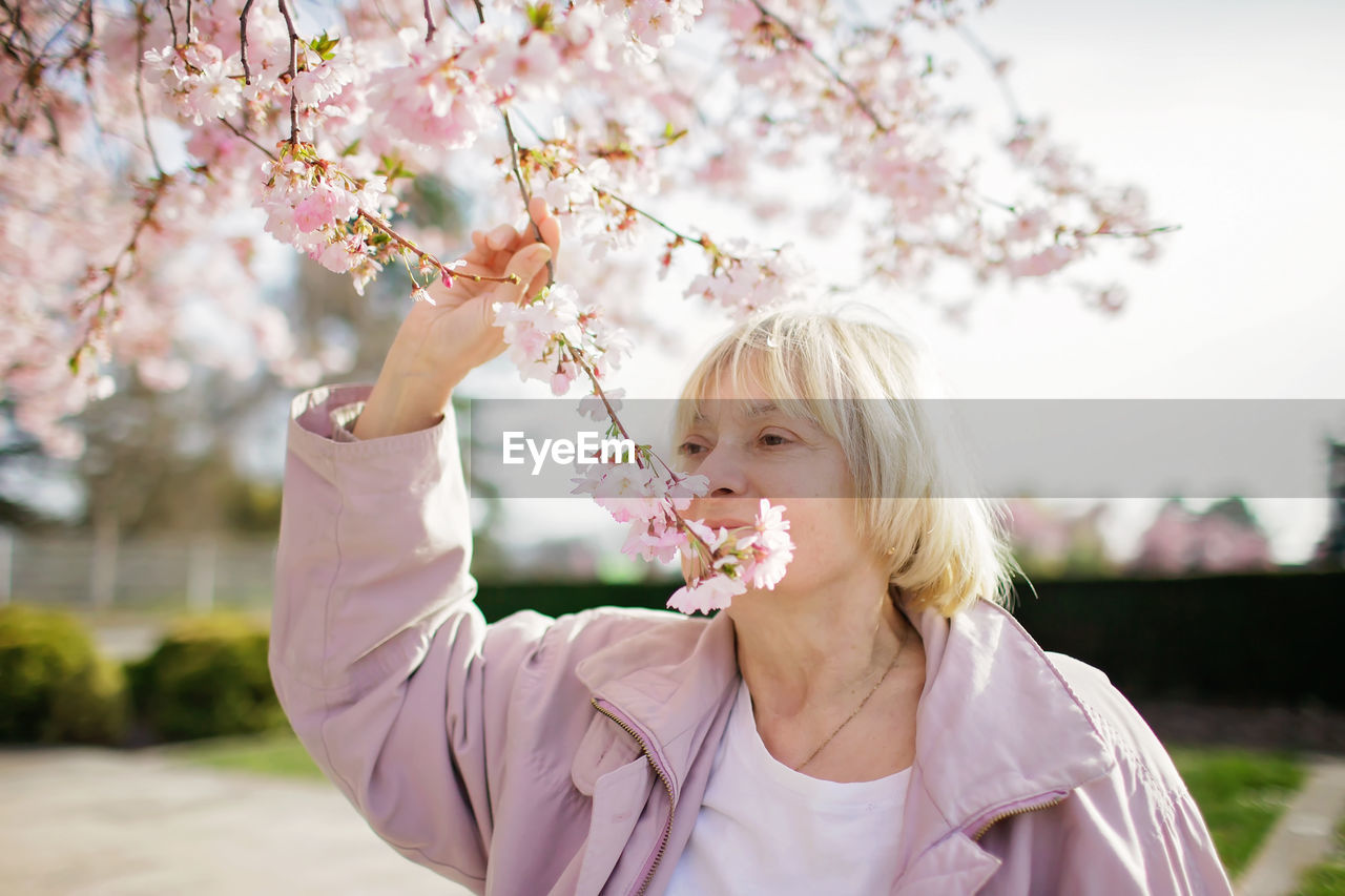 Portrait of woman near blowing flowers