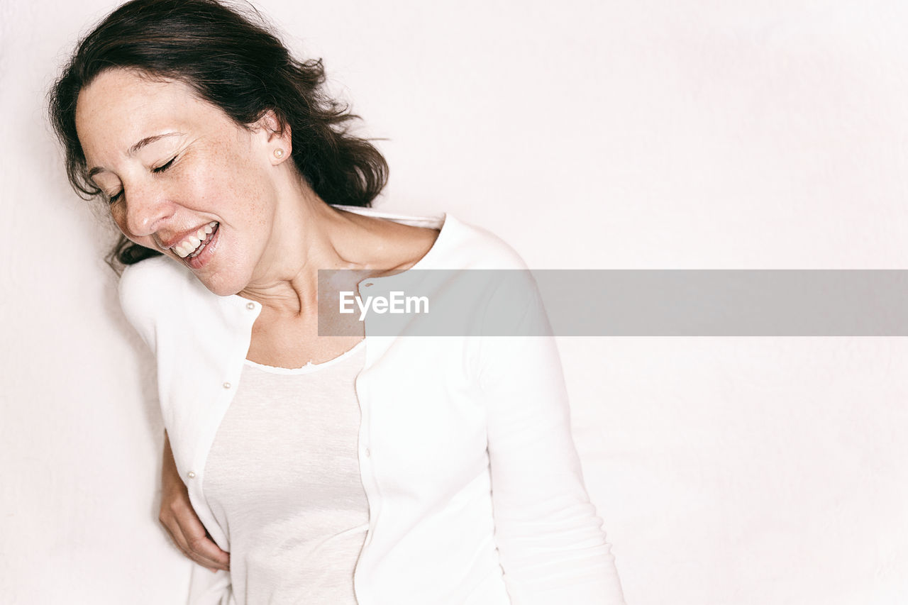 Smiling woman lying on bed at home