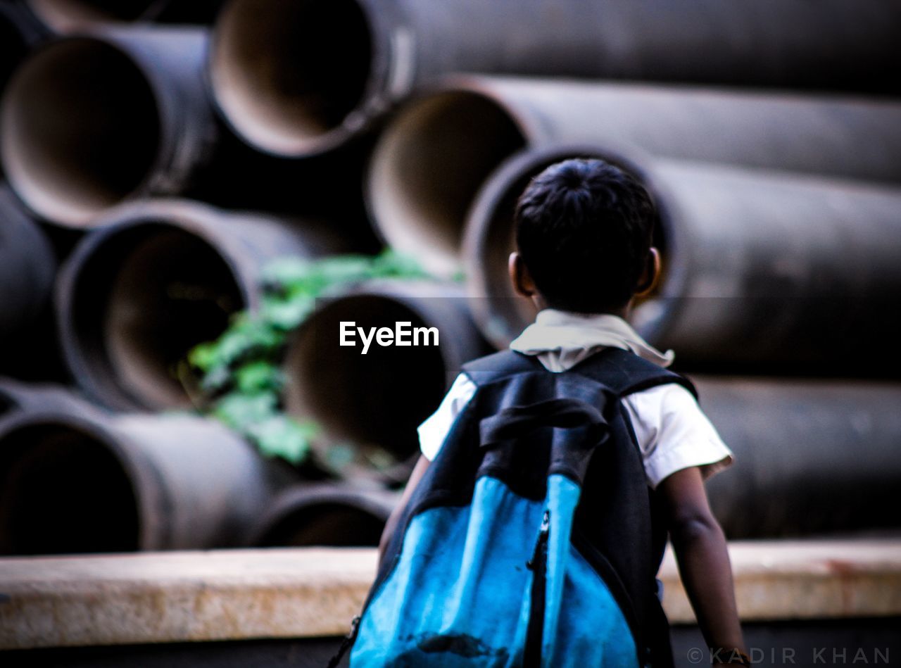 REAR VIEW OF BOY LOOKING UP