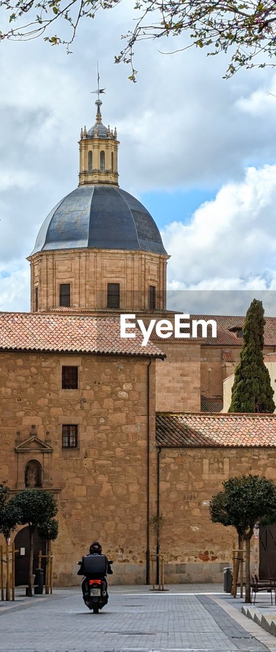 architecture, building exterior, built structure, religion, travel destinations, building, place of worship, city, travel, dome, cloud, nature, sky, belief, history, the past, town, transportation, tree, street, spirituality, tourism, mode of transportation, tower, outdoors, day, plant, road, no people, vehicle