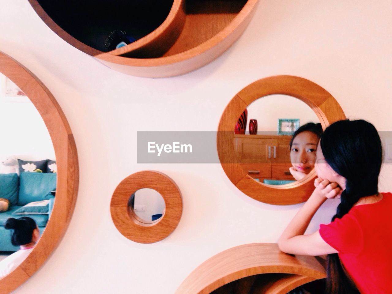 Portrait of pre-adolescent girl looking through mirror reflection