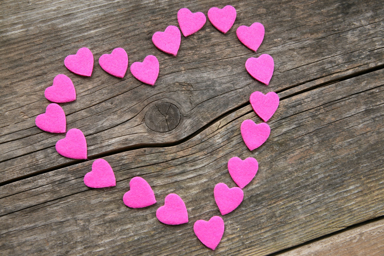 HIGH ANGLE VIEW OF PINK HEART SHAPED FLOWER ON TABLE