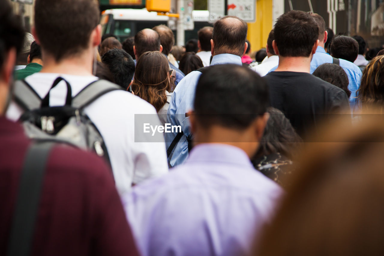 Rear view of people walking on street