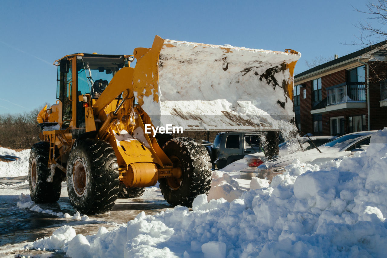 HIGH ANGLE VIEW OF CARS PARKED ON SNOW COVERED ROAD