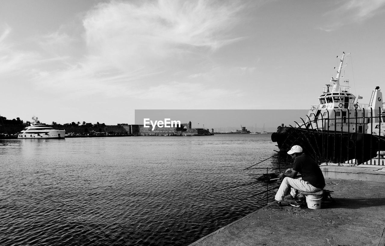 rear view of woman standing on sea