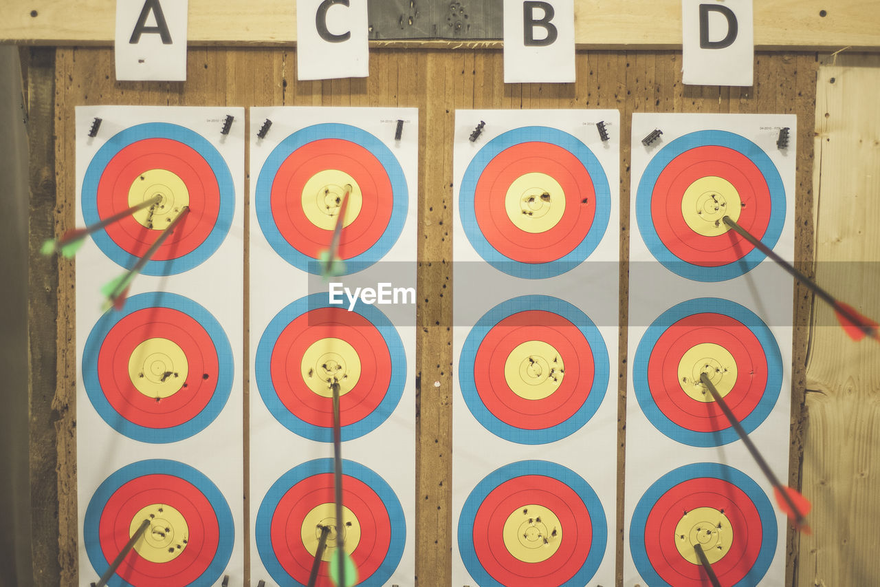 Close-up of darts on wooden wall