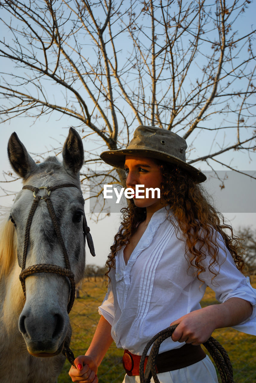 Photo session of a young girl dressed as a gaucho and her riding horse