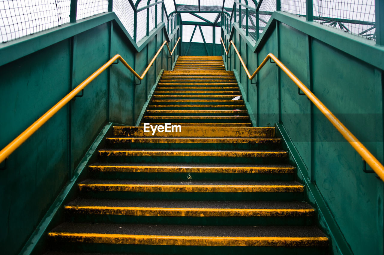 Low angle view of metallic steps against sky