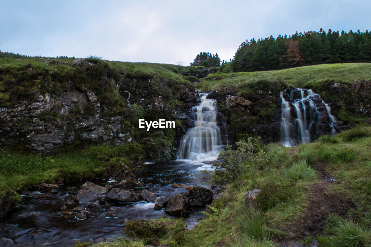 VIEW OF WATERFALL AGAINST SKY