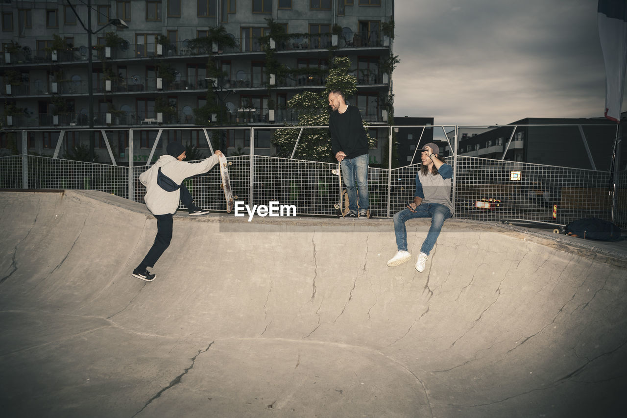 Male friends at skateboard park during dusk