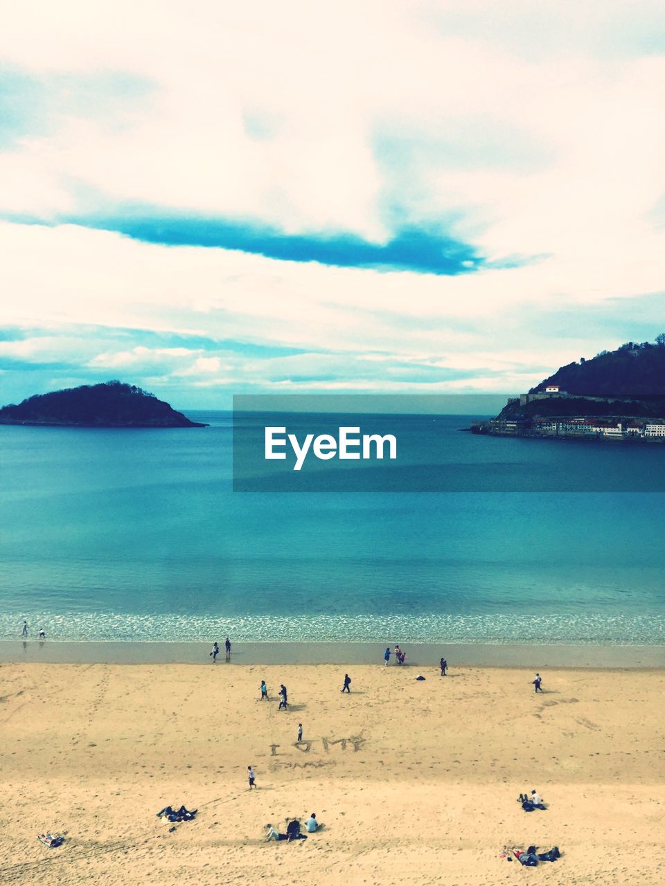 PEOPLE ON BEACH AGAINST SKY