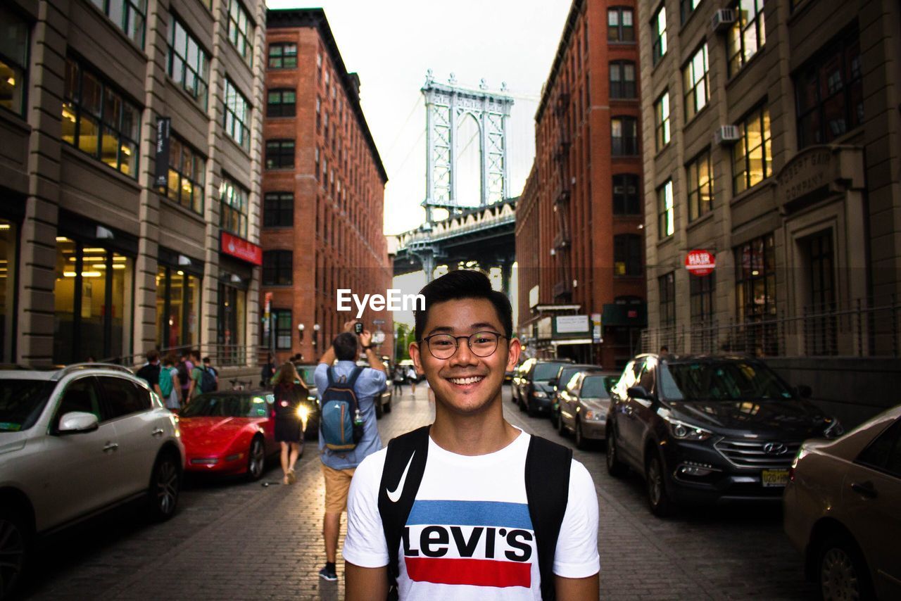 PORTRAIT OF SMILING YOUNG MAN IN CITY