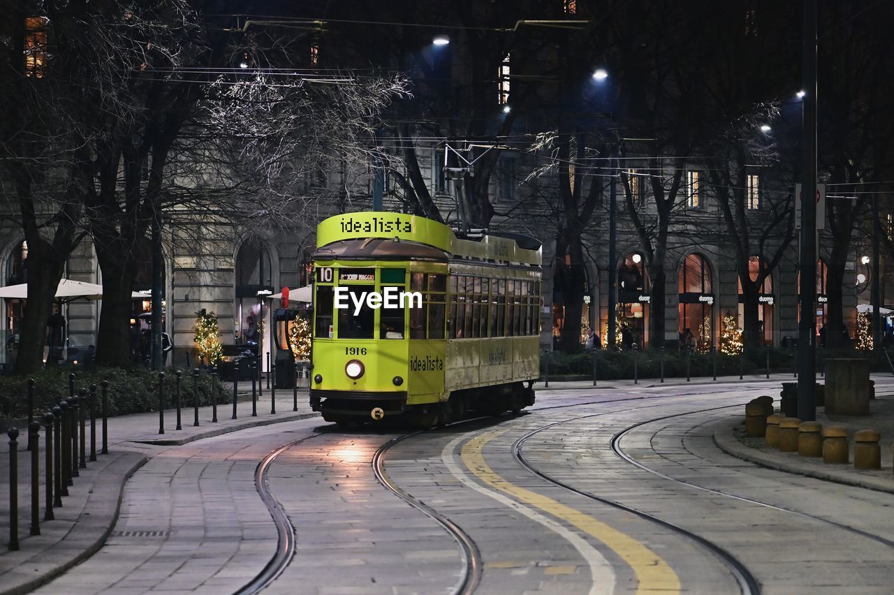 CARS ON ILLUMINATED CITY STREET AT NIGHT