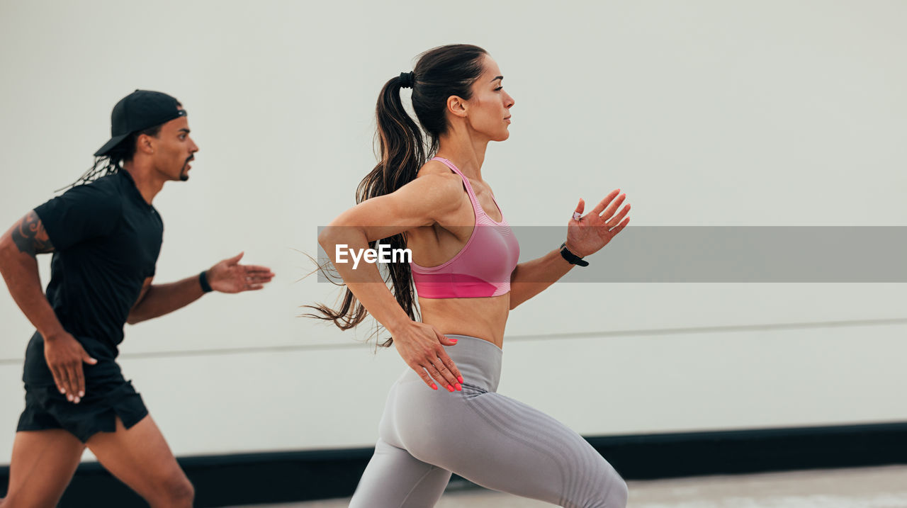 side view of female friends exercising in gym