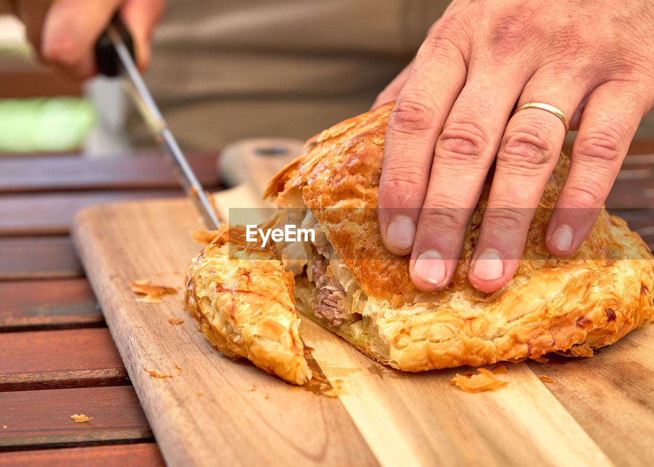 CLOSE-UP OF HAND HOLDING MEAT