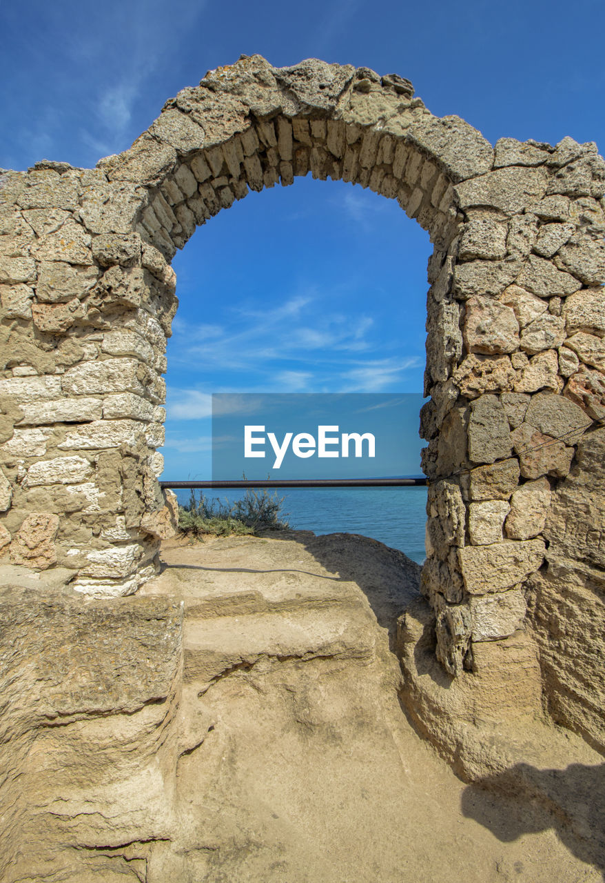 The arch of the ancient fortress of cape kaliakra above the sea against the background of the sky