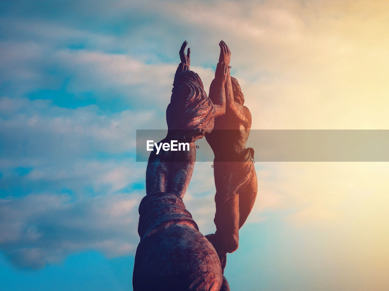 Low angle view of sculpture on rock against sky