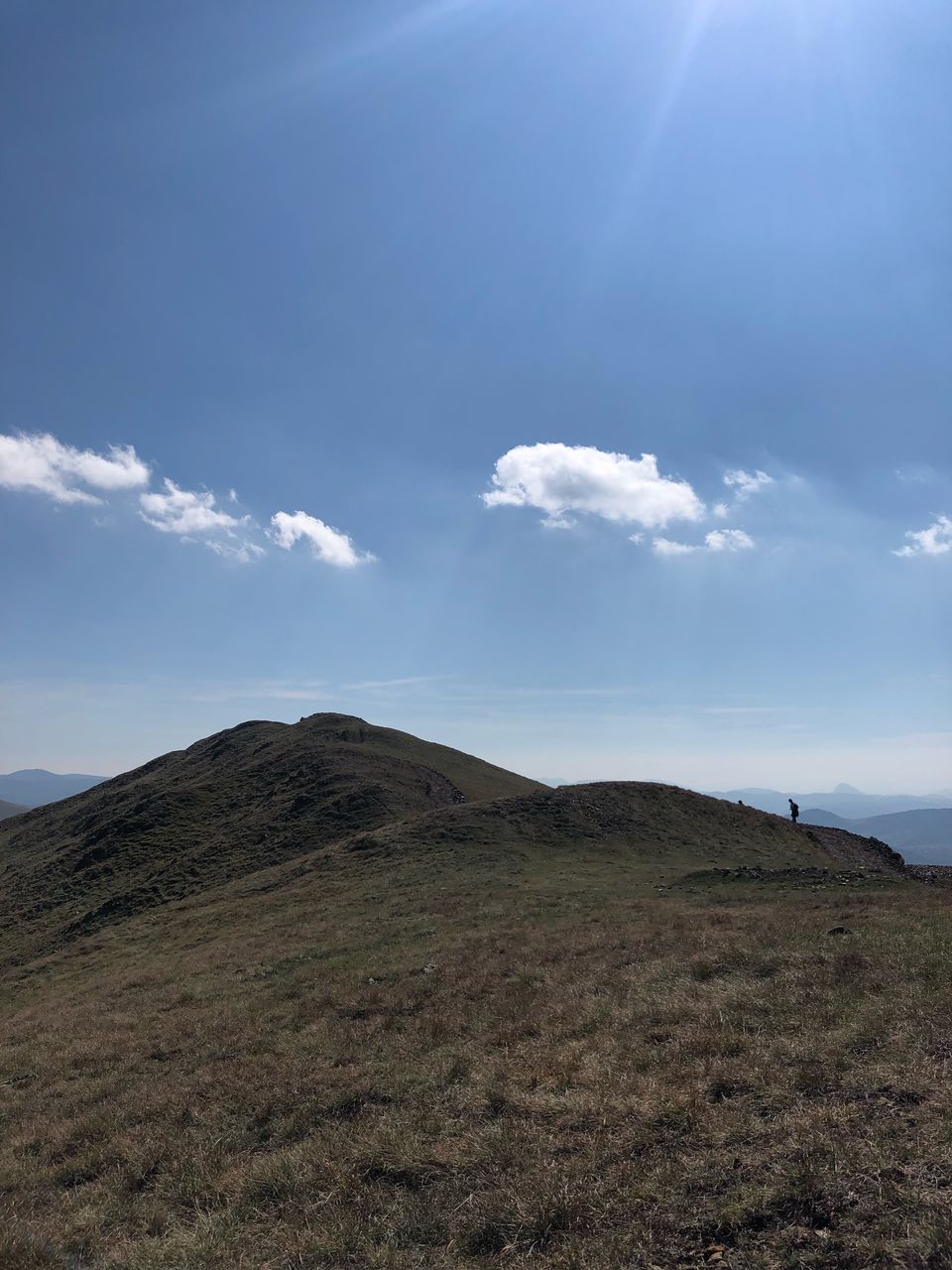 Scenic view of mountains against blue sky during sunny day