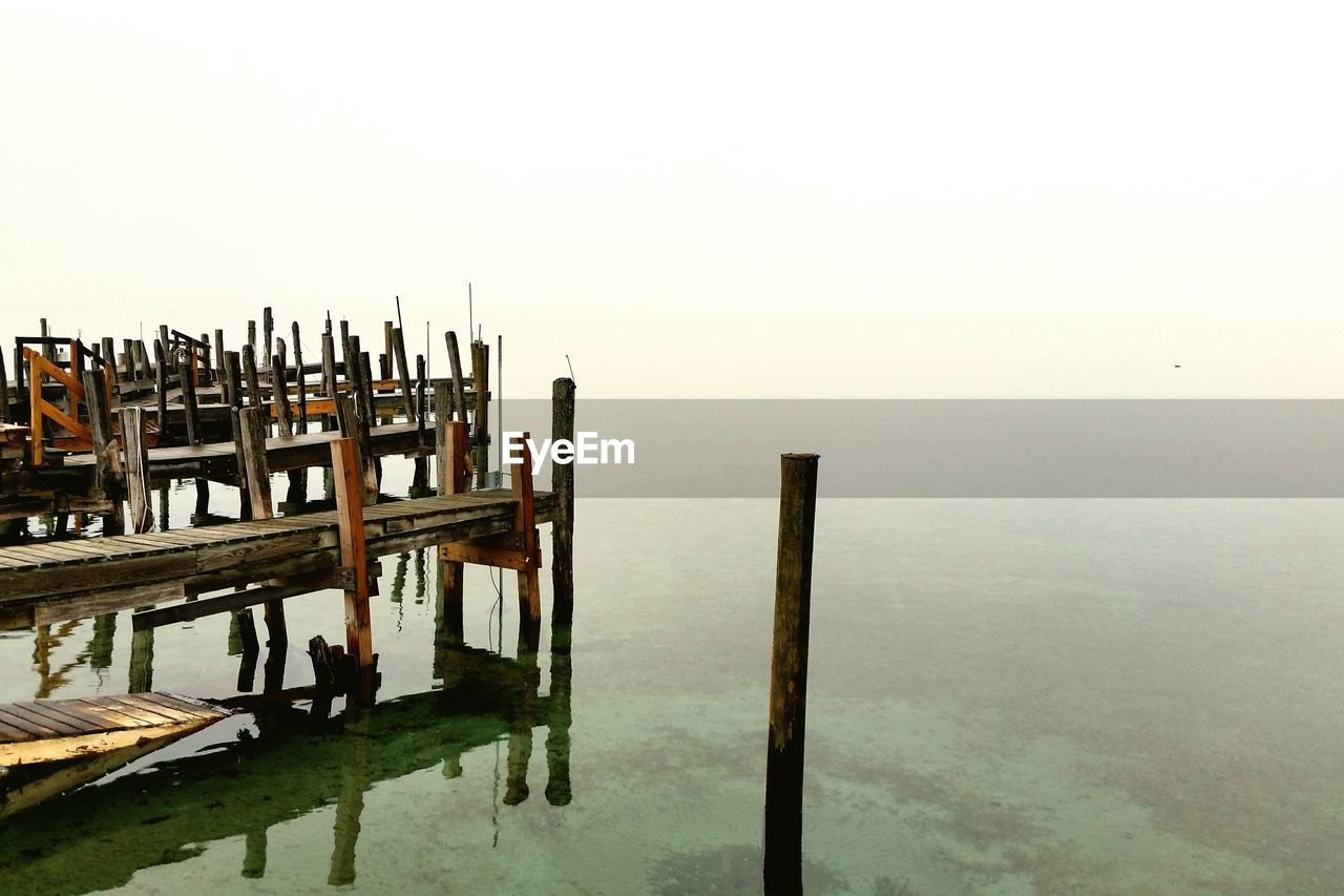 Wooden pier in lake against sky during foggy weather