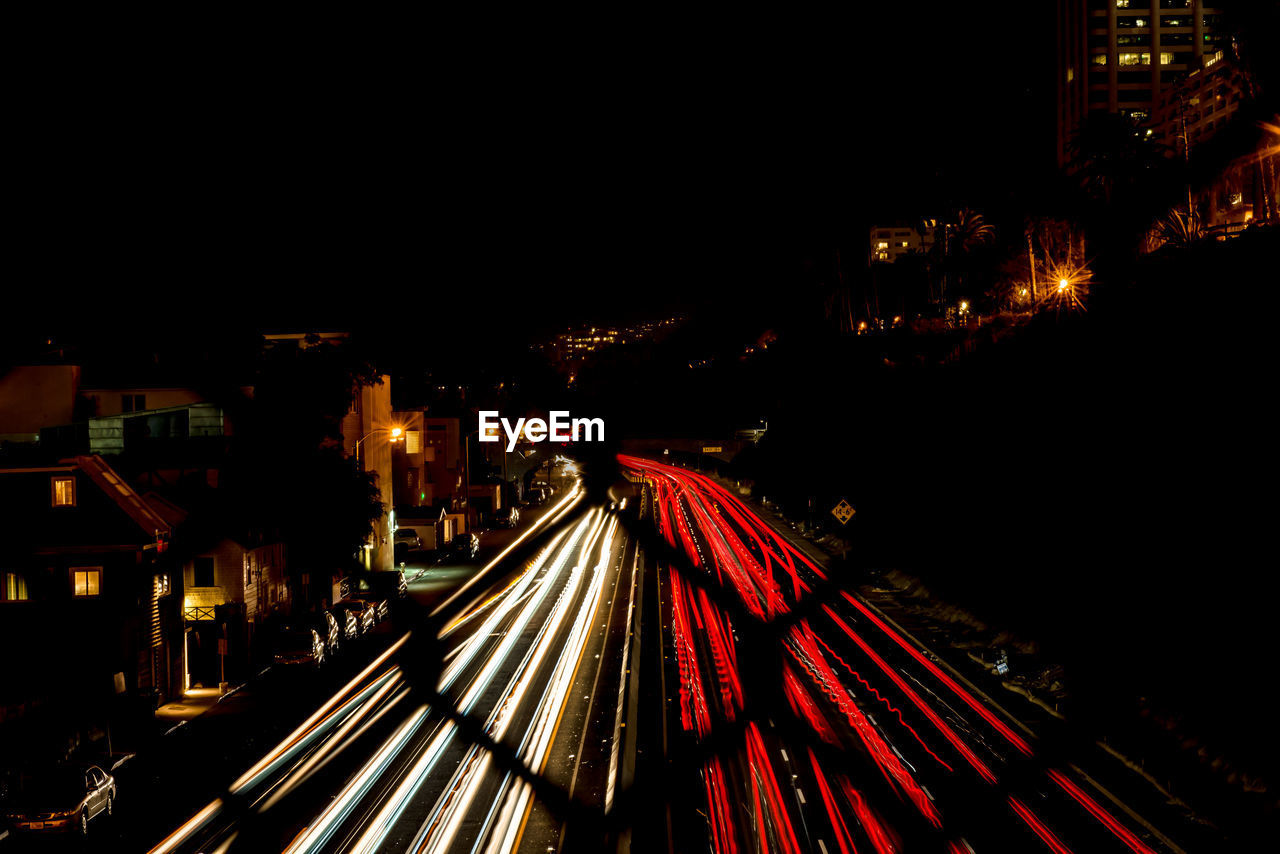 HIGH ANGLE VIEW OF LIGHT TRAILS ON RAILROAD TRACKS AT NIGHT