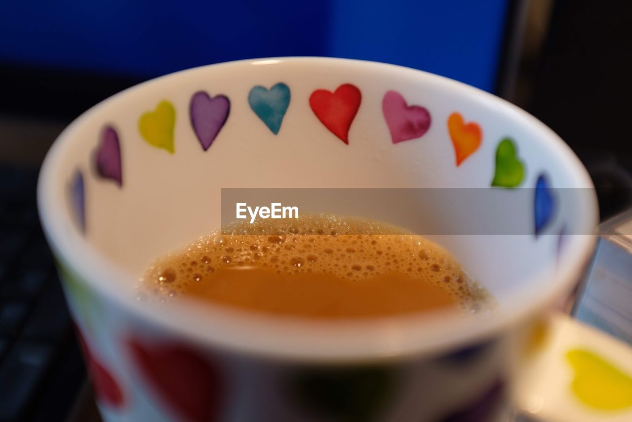 Close-up of coffee cup with colorful heart shapes