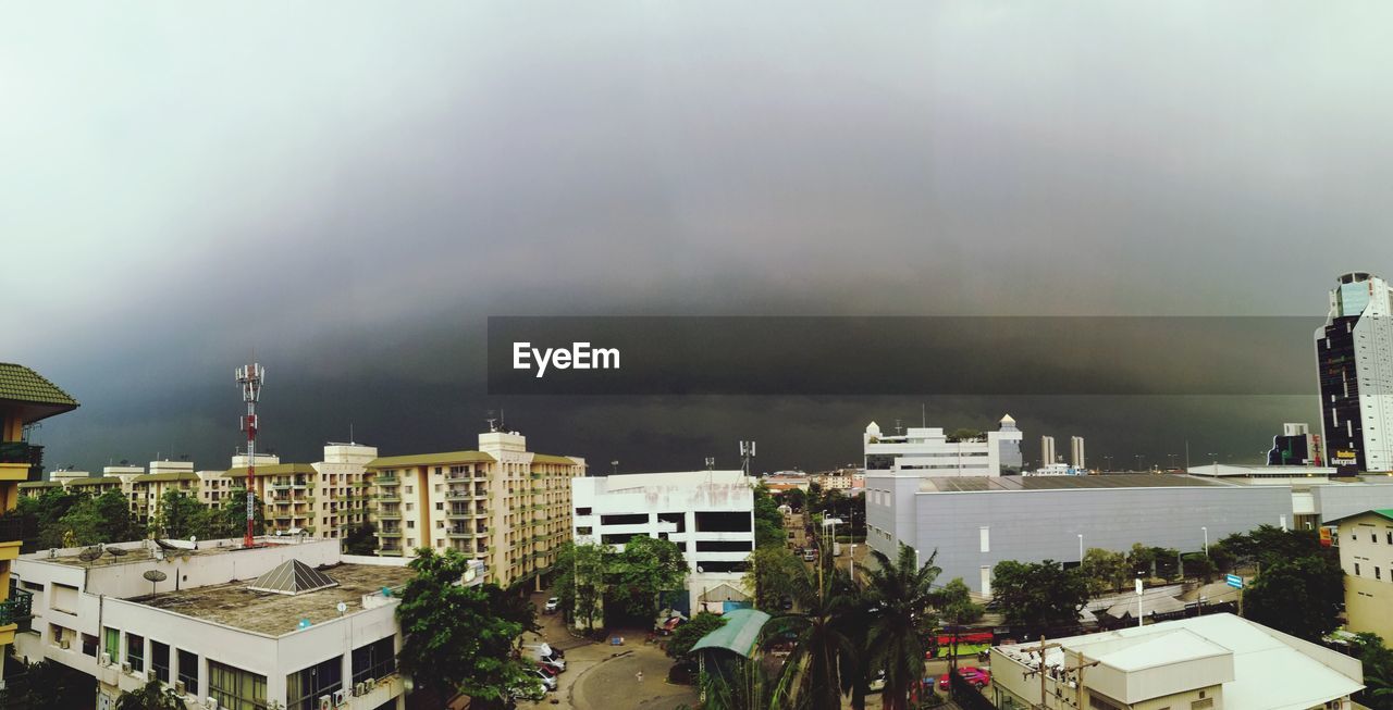 HIGH ANGLE VIEW OF CITY BUILDINGS AGAINST CLOUDY SKY