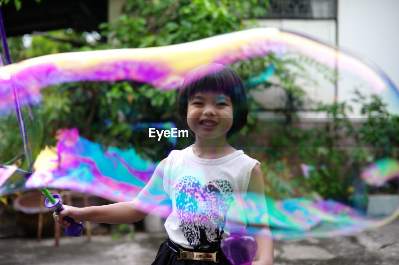 Happy girl playing with bubble