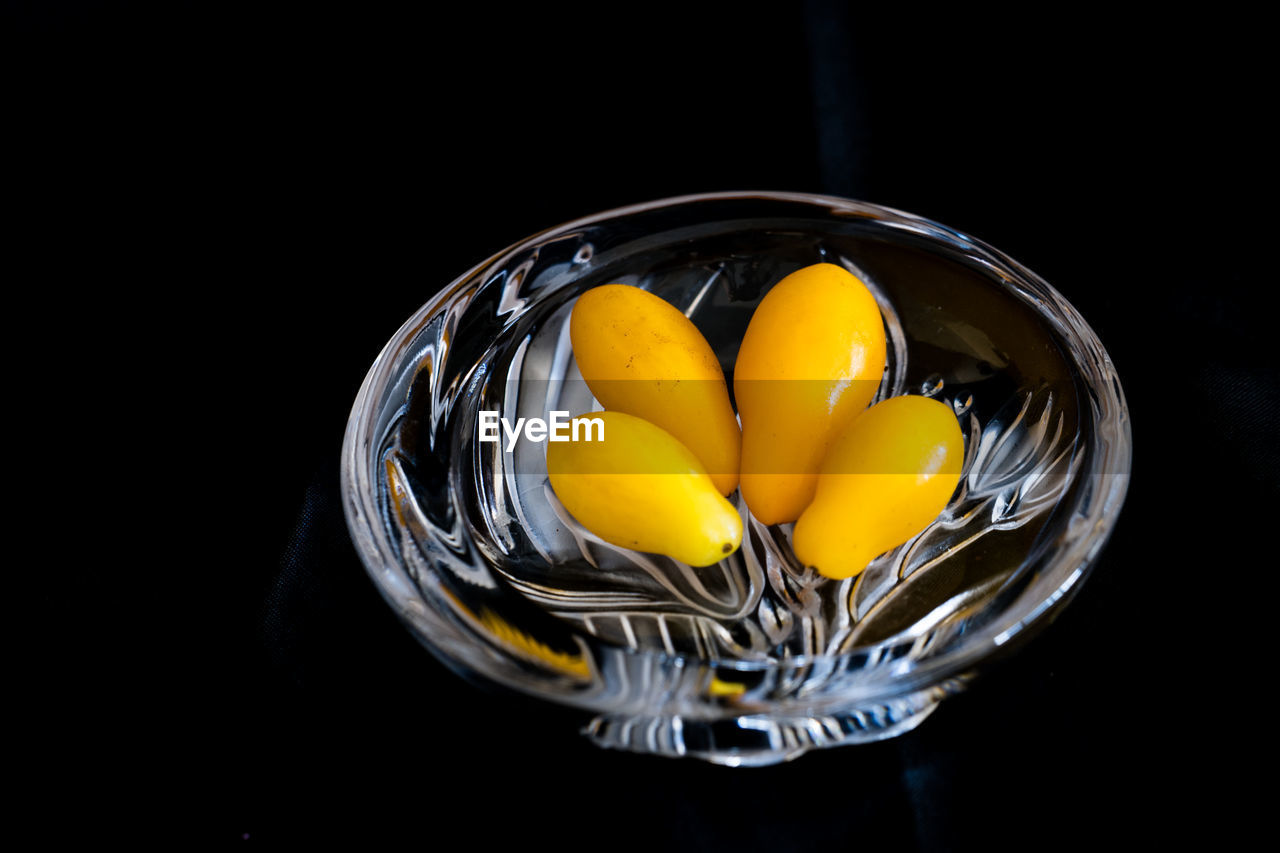 Close-up of tomatoes in bowl on black background