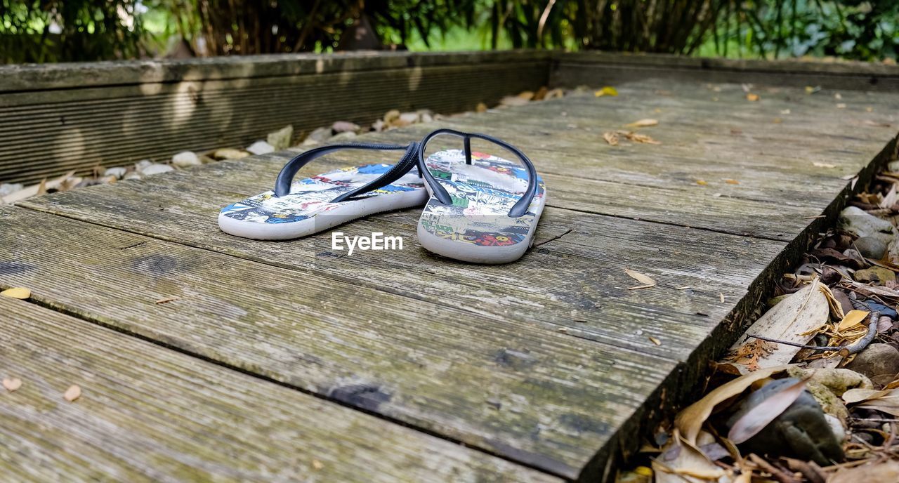 Close-up of shoes on wooden bench