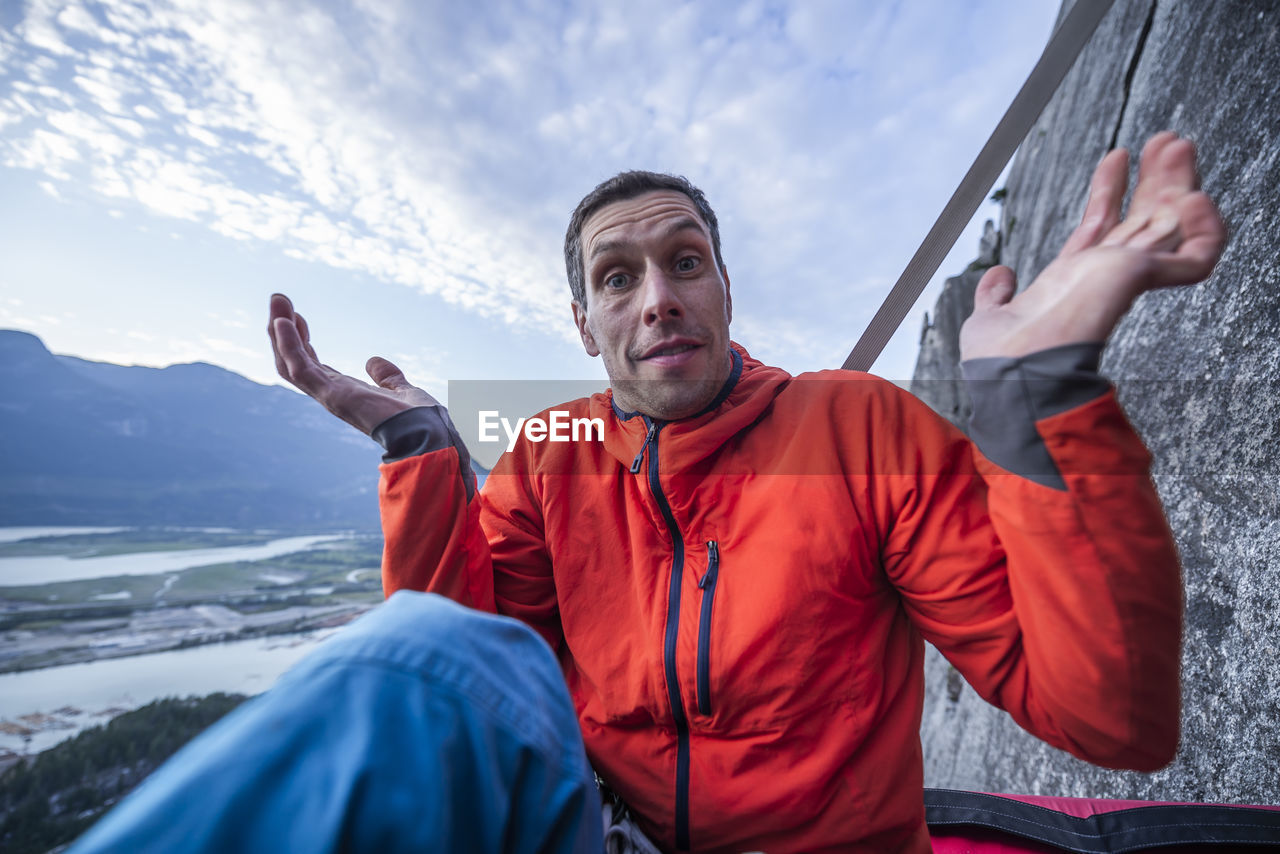 Man with surprised look showing interrogation on portaledge at sunset