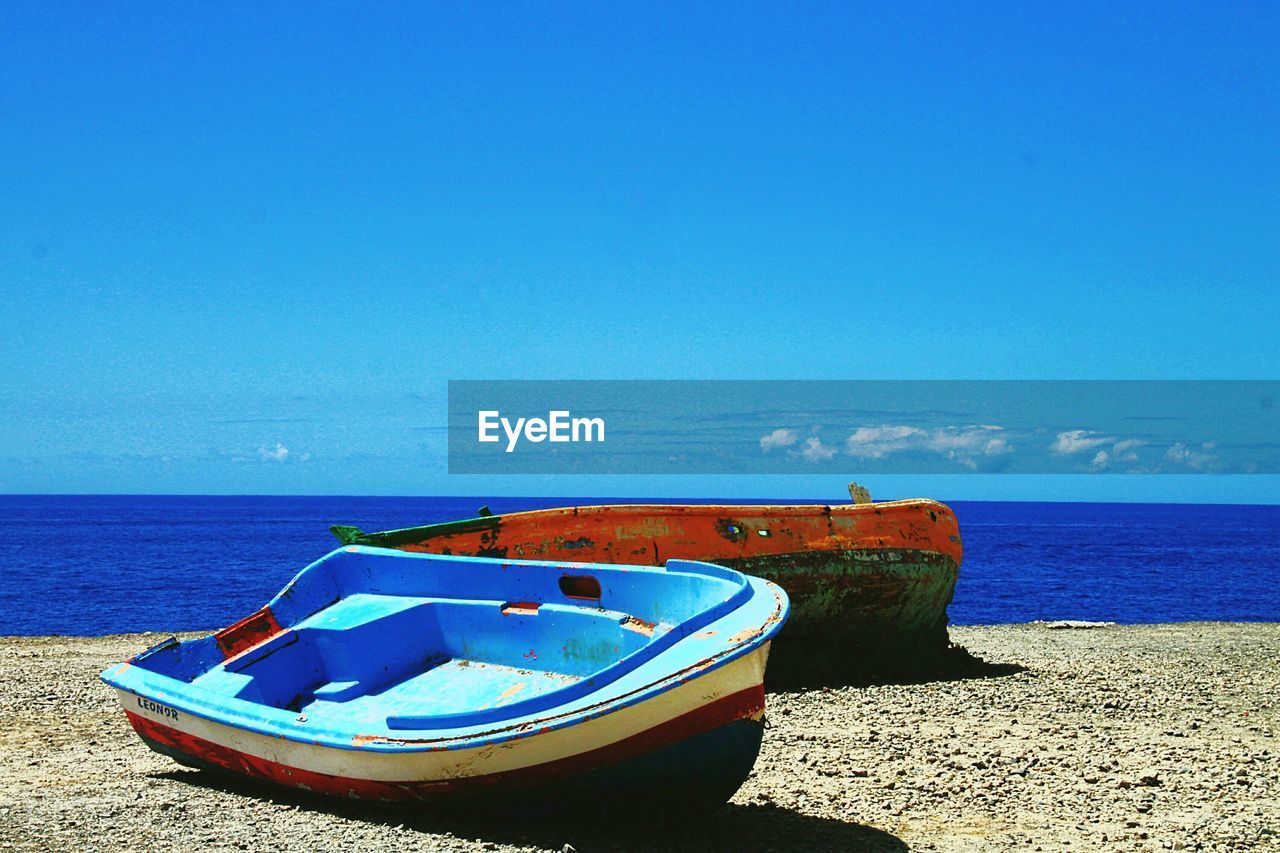 water, sea, beach, nautical vessel, sky, land, blue, transportation, nature, boat, mode of transportation, vehicle, sand, moored, horizon over water, scenics - nature, horizon, tranquility, clear sky, beauty in nature, sunlight, no people, watercraft, long-tail boat, tranquil scene, day, shore, ocean, travel, sunny, outdoors, travel destinations, bay, dinghy, idyllic, coast, copy space, holiday, coastline, non-urban scene, rowboat, vacation