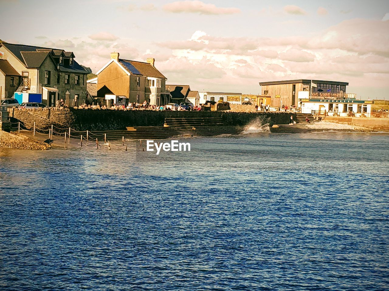 Houses by sea against sky in city