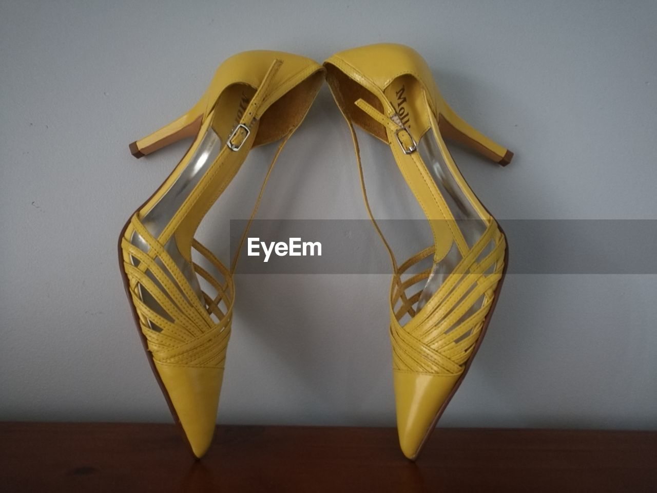 CLOSE-UP OF SHOES HANGING ON TABLE