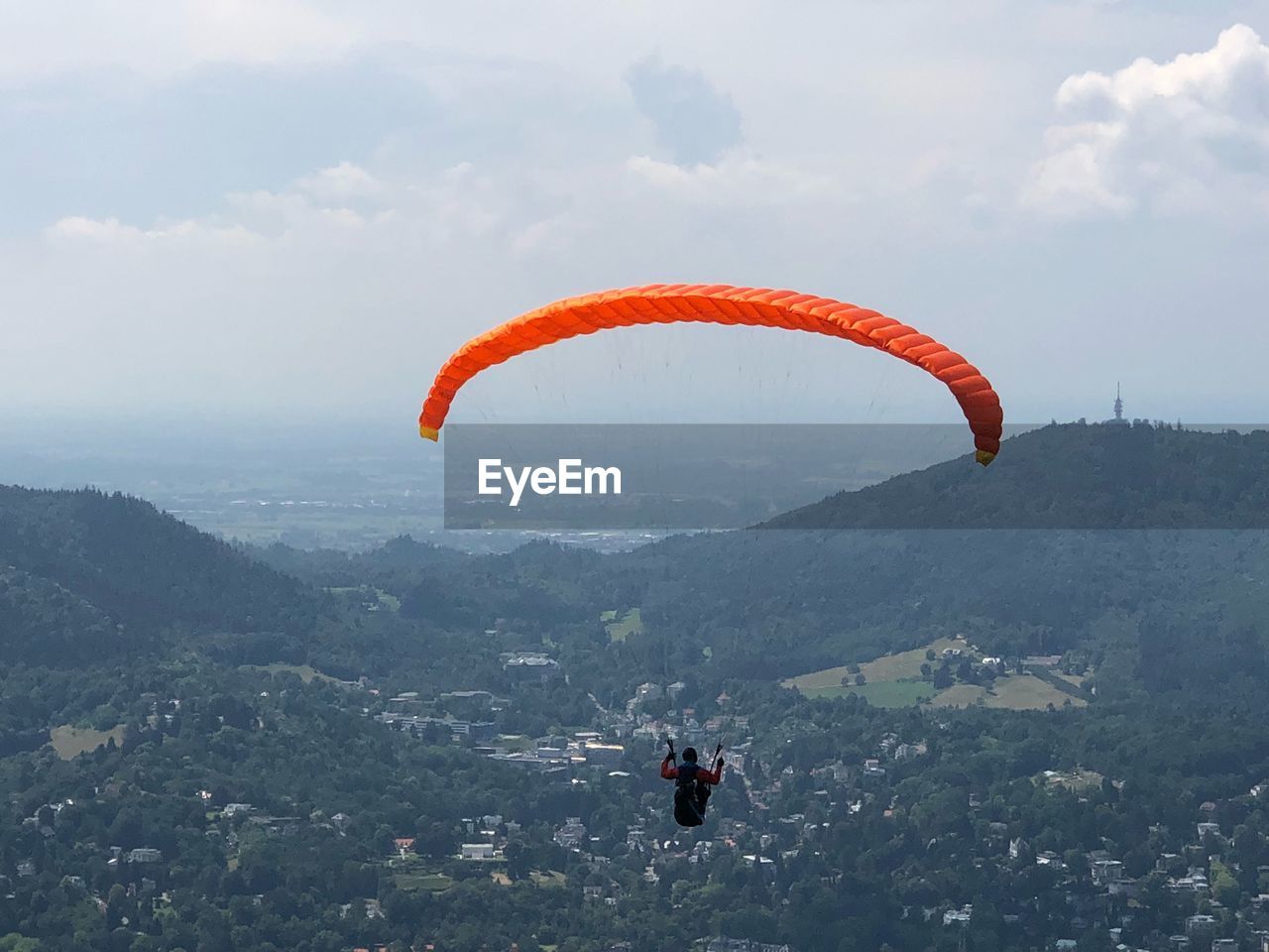 PERSON PARAGLIDING AGAINST MOUNTAINS