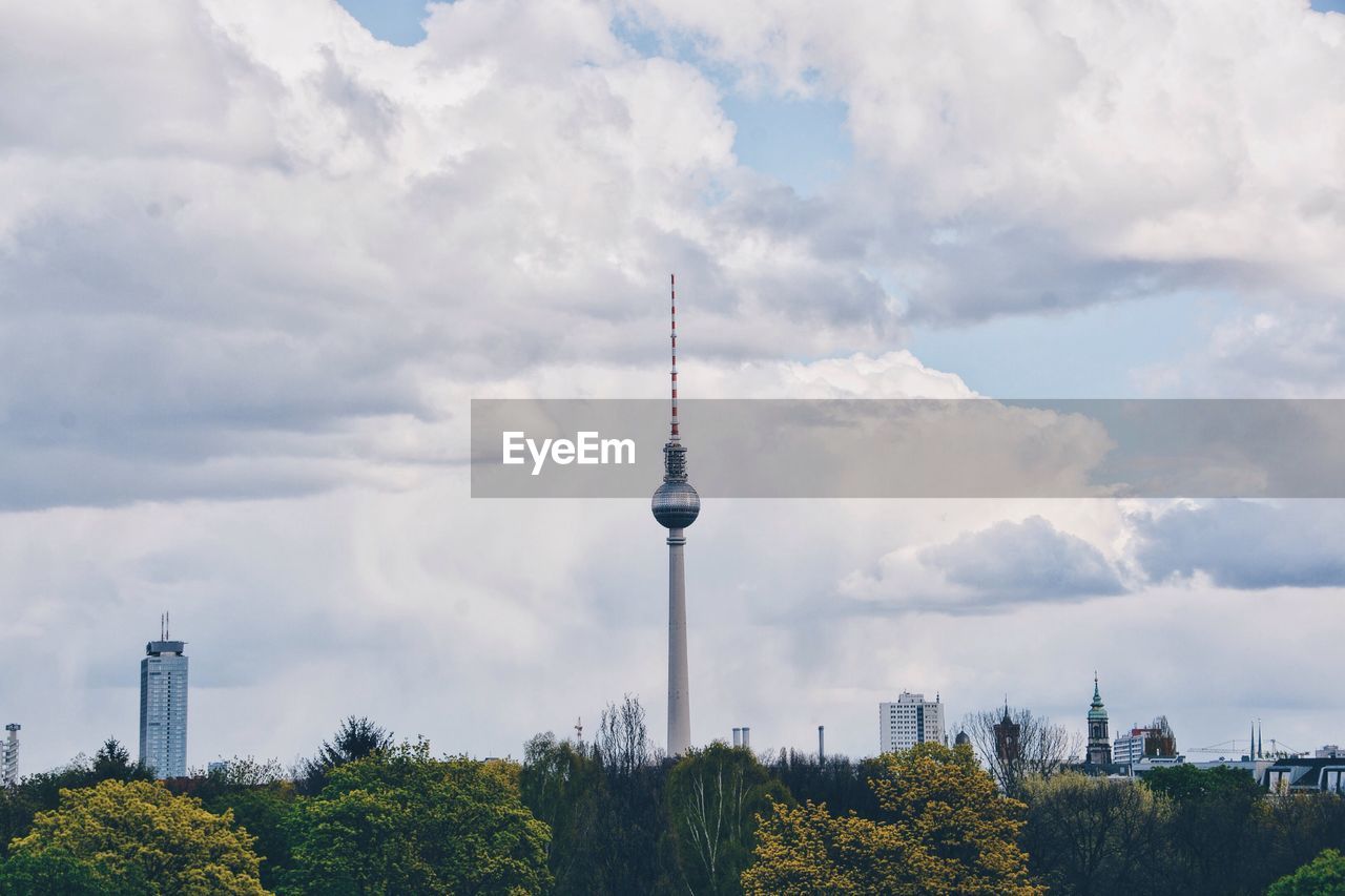 Low angle view of fernsehturm against cloudy sky