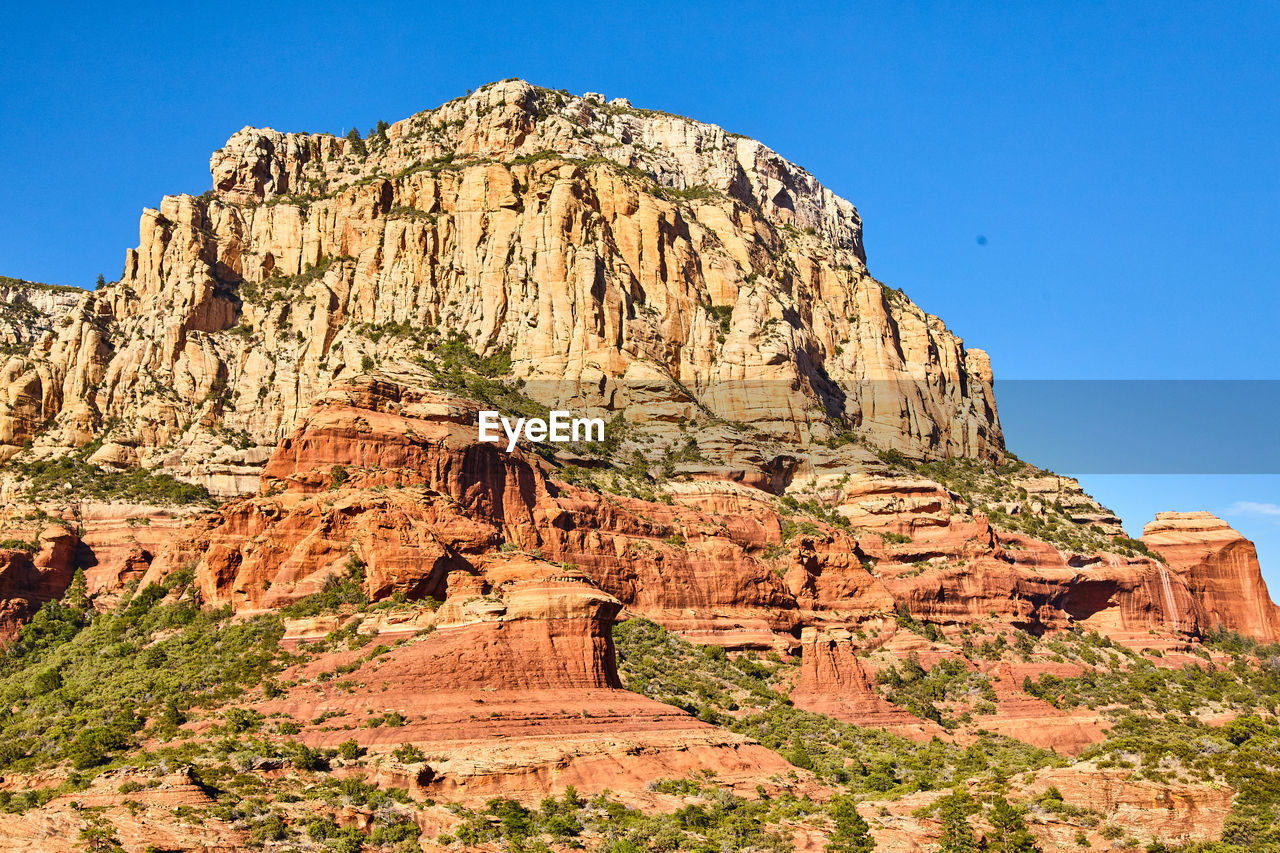 rock formations on landscape against clear blue sky