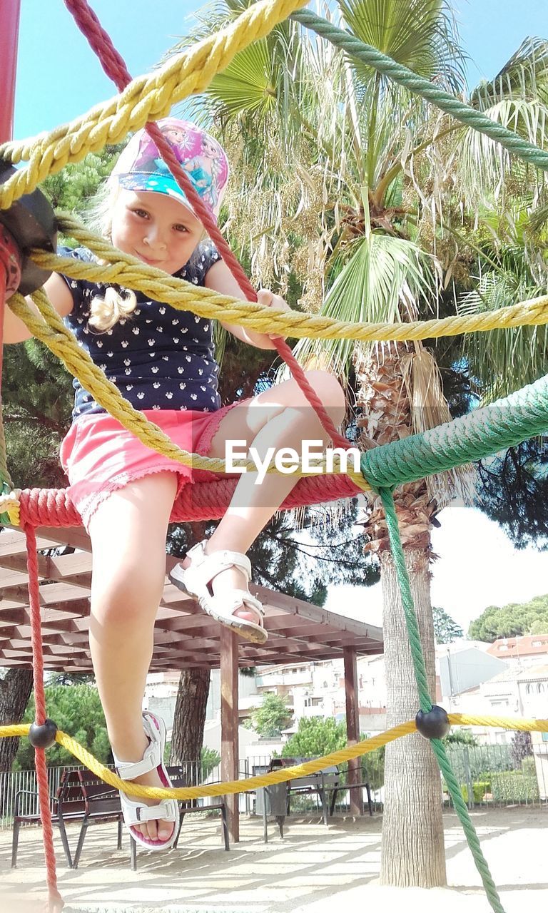 Portrait of girl playing on jungle gym at playground
