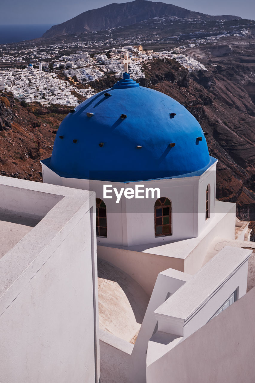 Anastasis church with its blue dome and tower in imerovigli village, santorini, greece