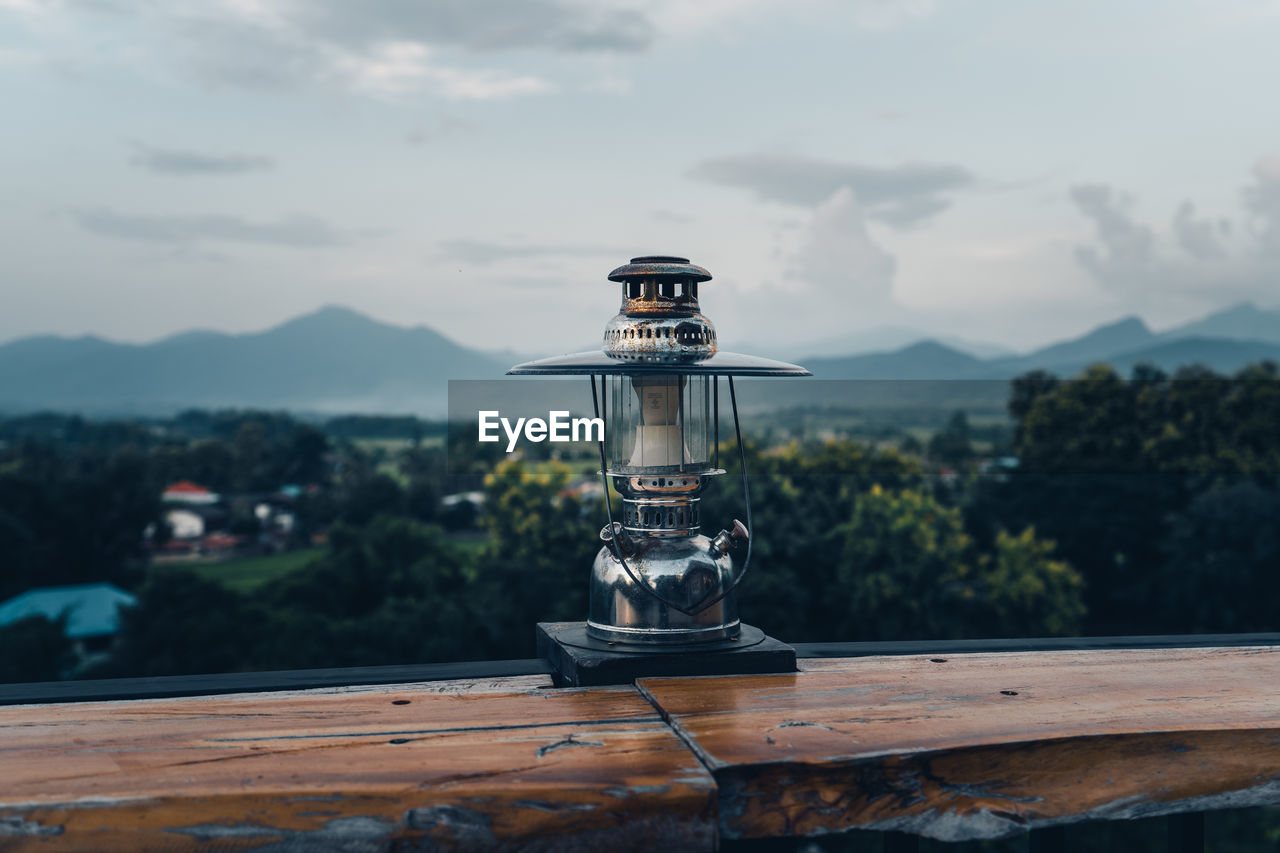 View of lantern on table against mountain