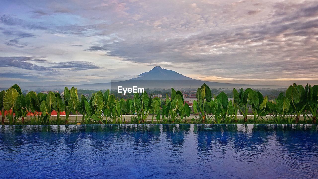 SCENIC VIEW OF LAKE BY MOUNTAIN AGAINST SKY