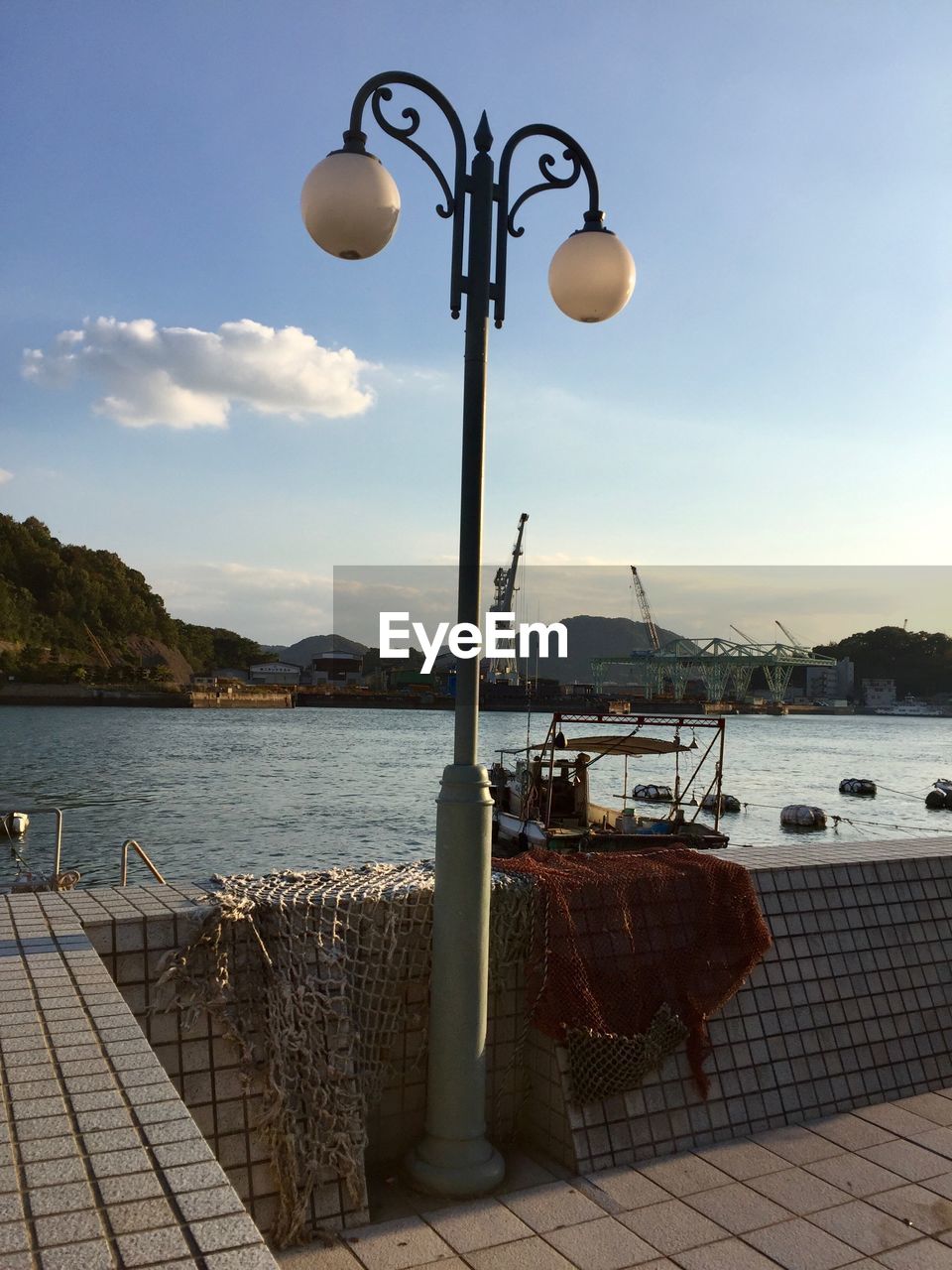 STREET LIGHT AND SEA AGAINST SKY