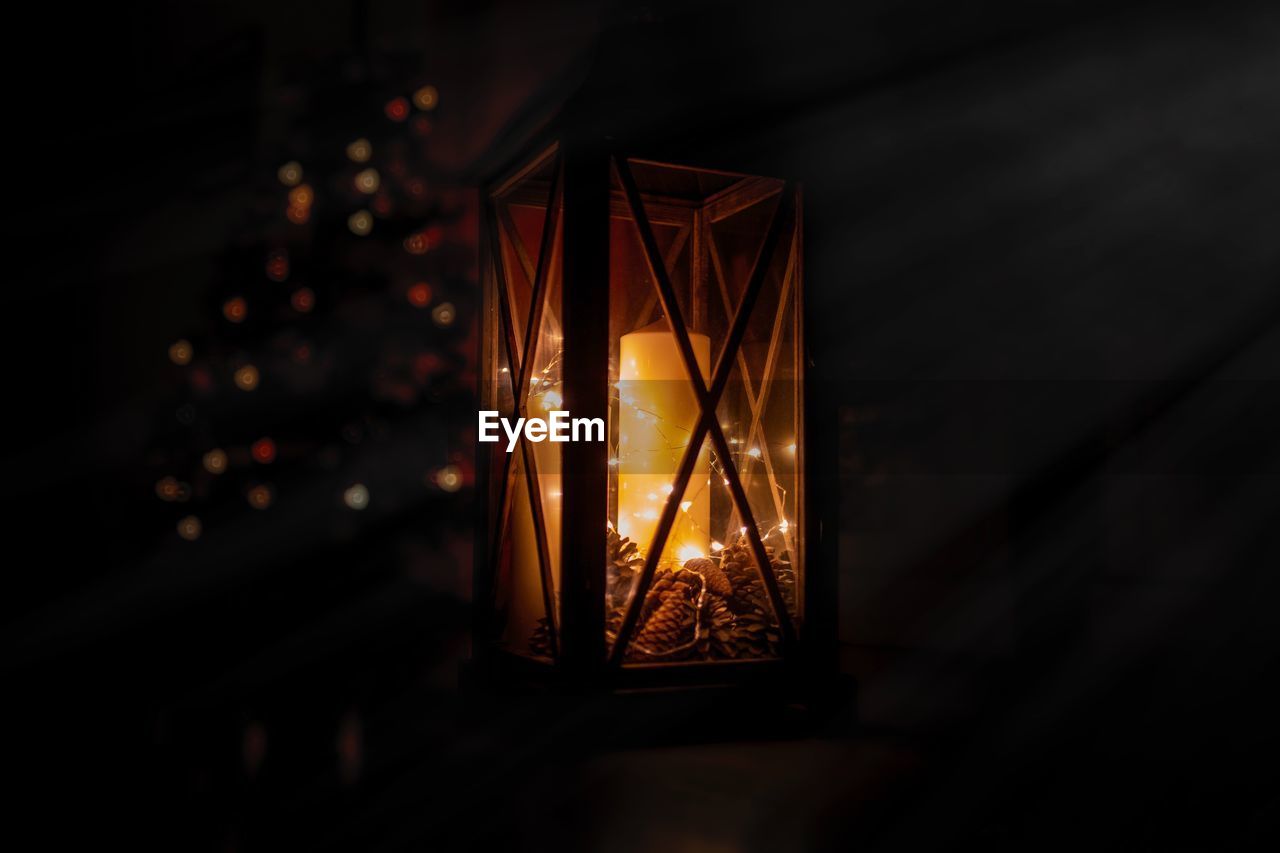 Close-up of illuminated candle in lantern at night