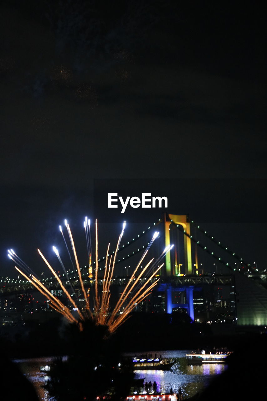 FIREWORK DISPLAY IN CITY AGAINST SKY AT NIGHT