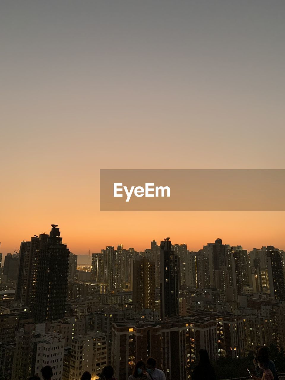 Illuminated cityscape against sky during sunset