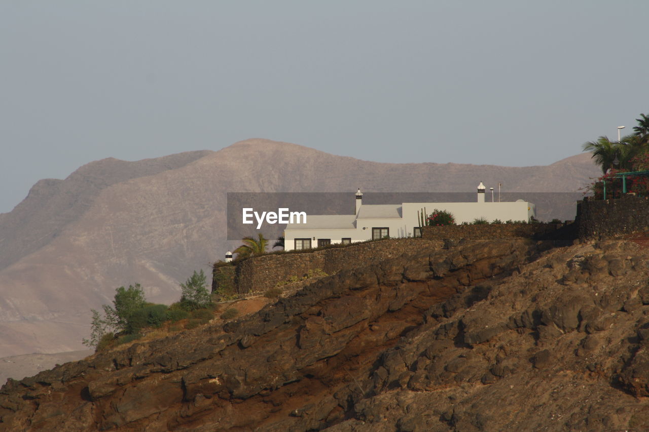 Buildings on mountain against clear sky