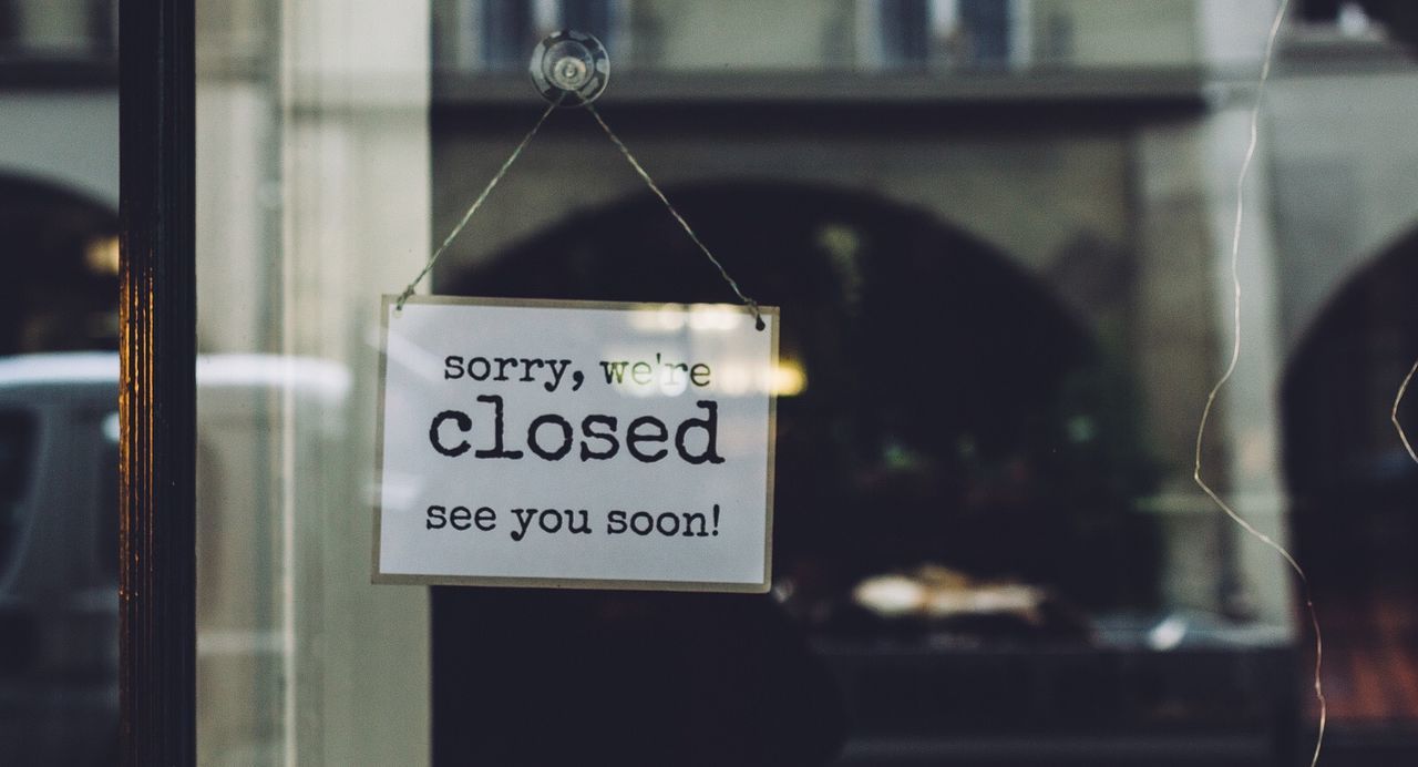 Closed sign on glass wall of store