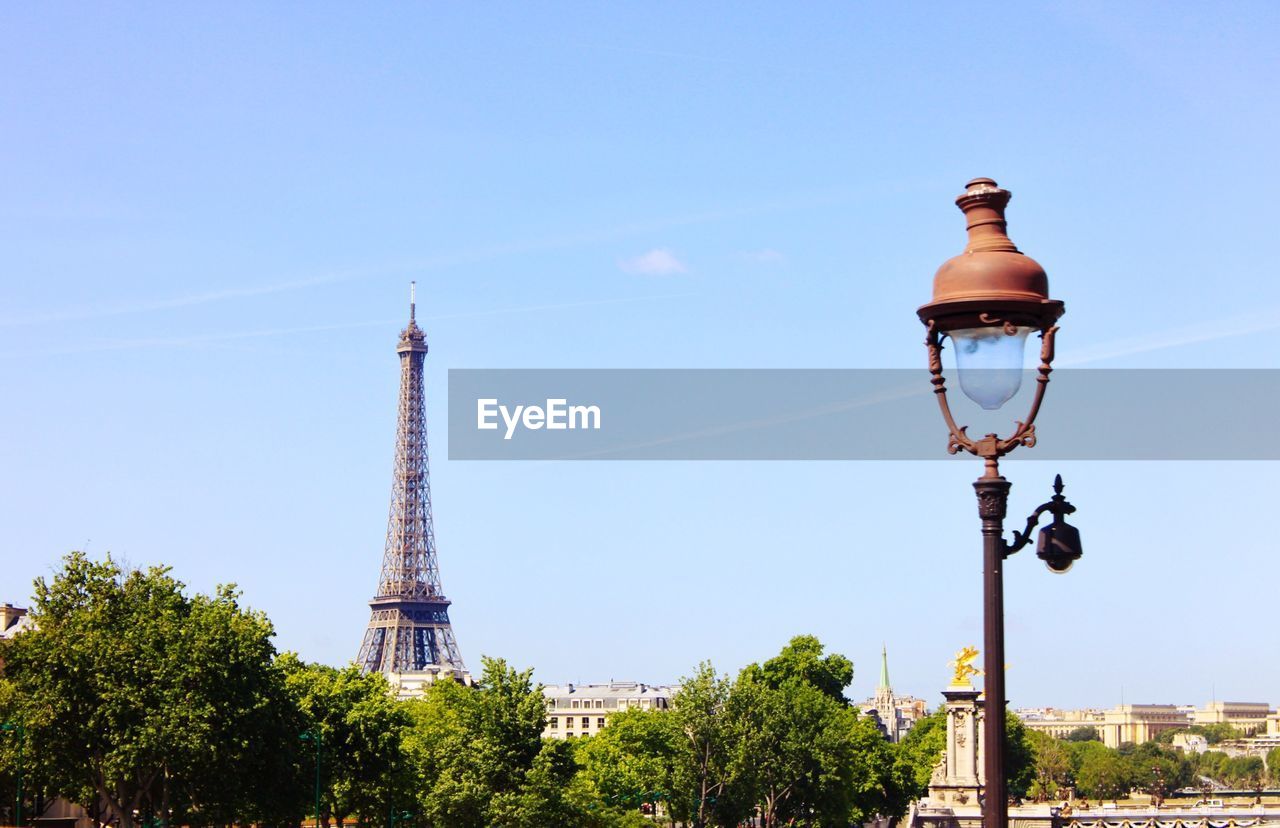 Low angle view of street light and eiffel tower against sky on sunny day