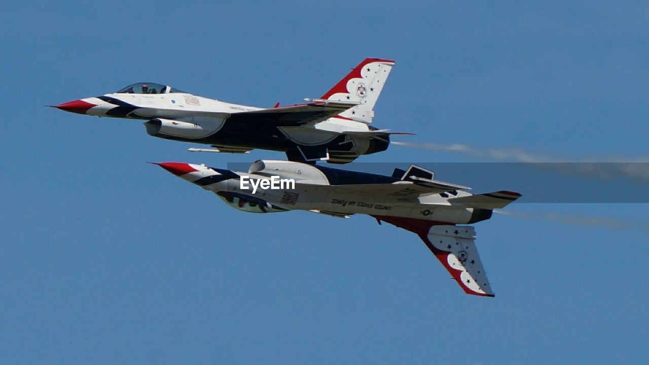 Low angle view of fighter airplanes flying against clear sky