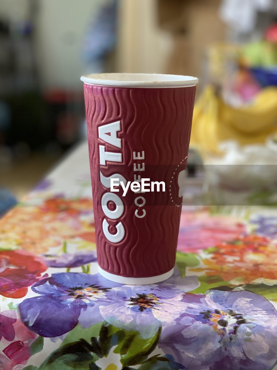 CLOSE-UP OF COFFEE CUP ON TABLE WITH TEXT