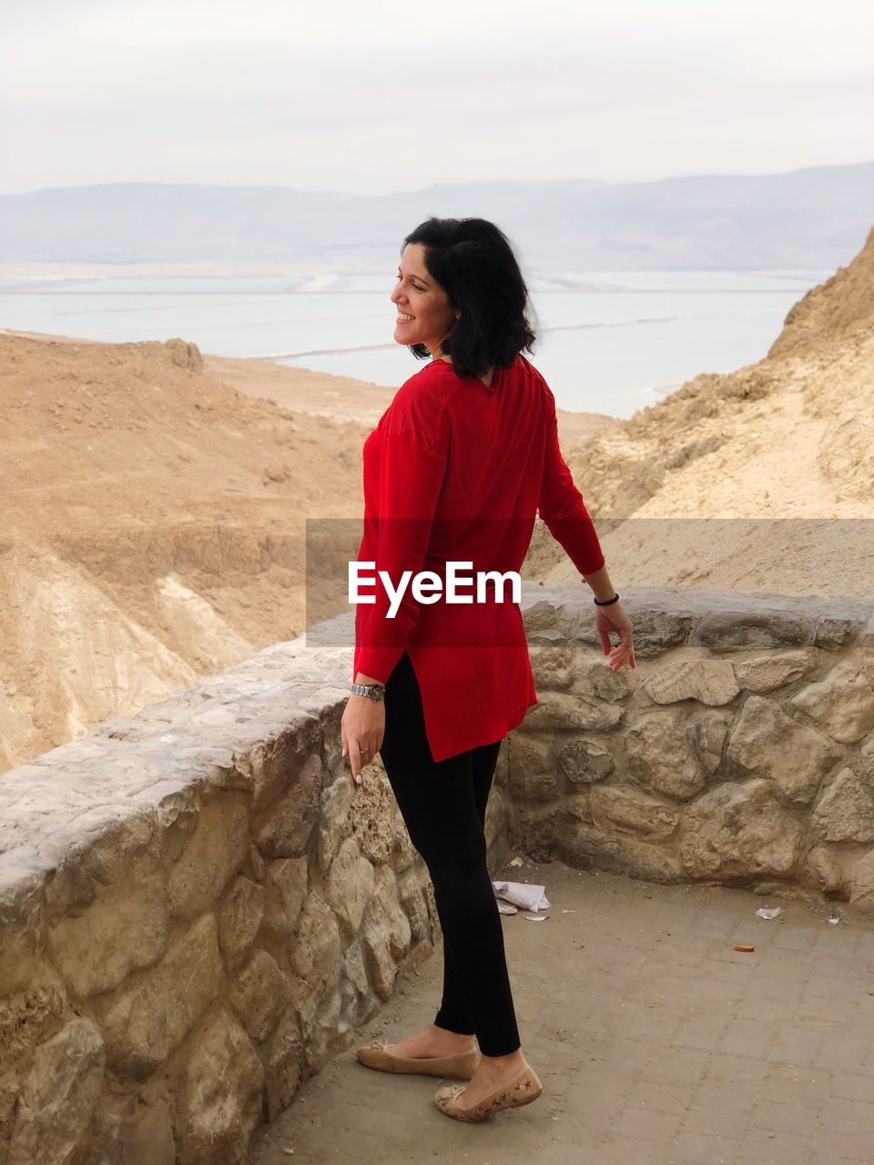 Woman standing at observation point against lake